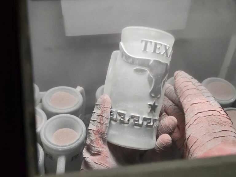 Handcrafted deep engraved glassware being worked by hand during the sandblasting process