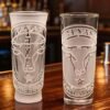 Texas engraved Longhorn Emblem shot glasses on wooden bar counter